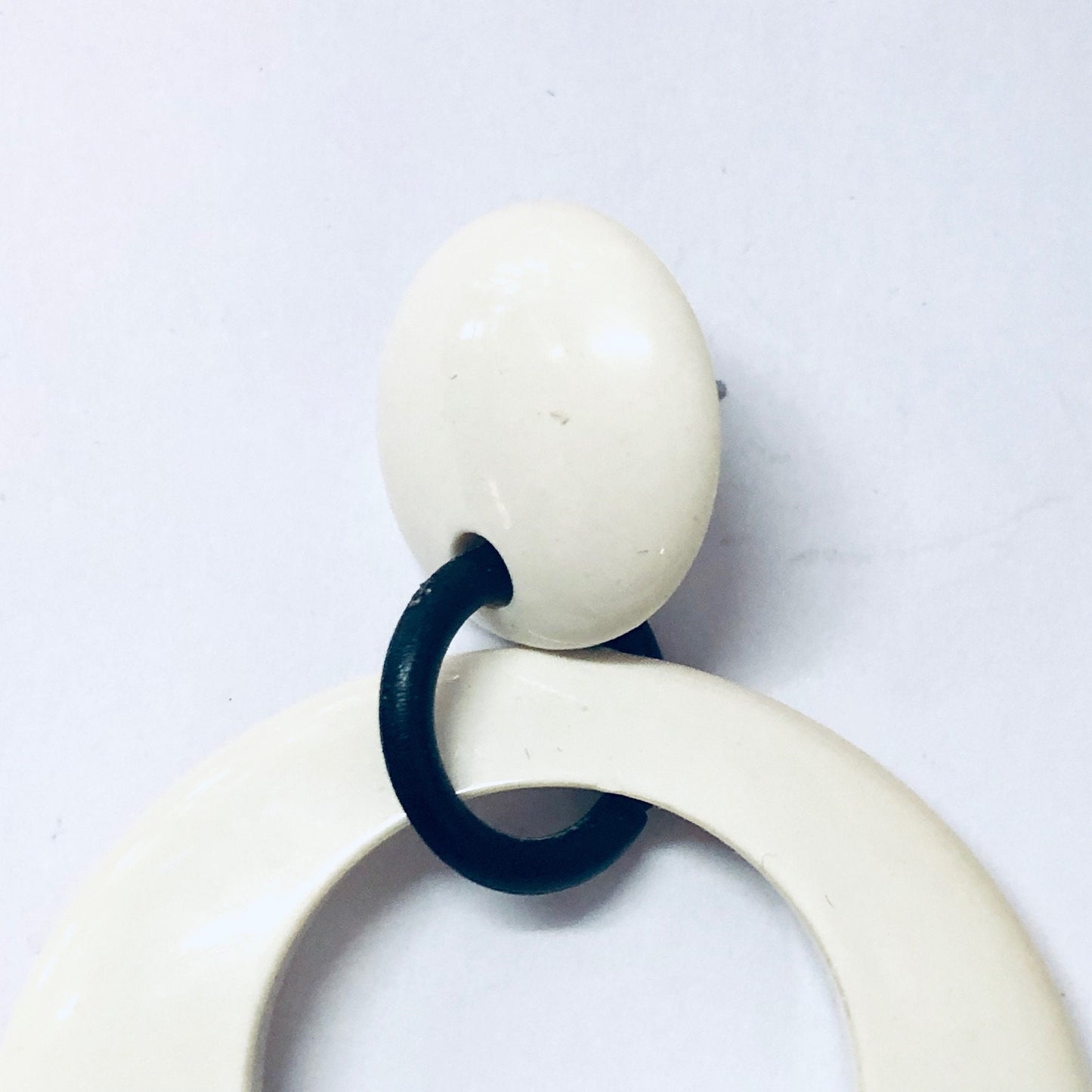 Vintage white and black plastic dangle earrings from the 1970s, large minimalist costume jewelry for pierced ears.