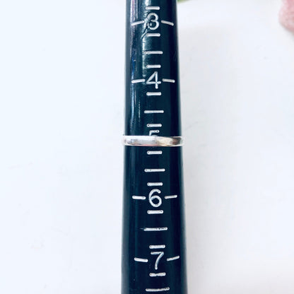 The image shows a close-up view of measurement markings on an old, dark blue metal ruler or measuring stick. The markings from 1 to 7 can be clearly seen etched in silver on the worn blue surface, indicating this is likely part of a vintage measuring tool.