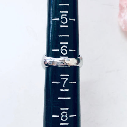 Vintage silver ring with rope design and faux diamond, sitting on a navy blue ruler showing ring size markings from 5 to 8.