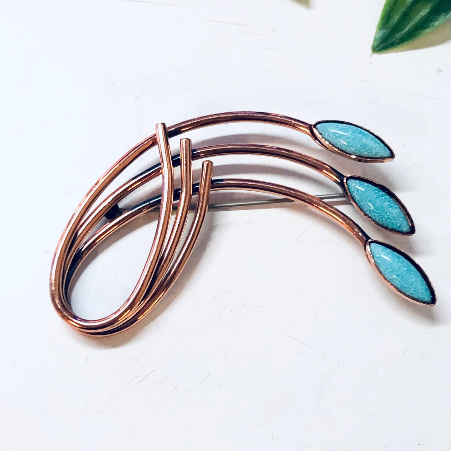 Vintage copper brooch with blue turquoise stones in a unique curved design, reminiscent of Matisse or Renoir style costume jewelry.