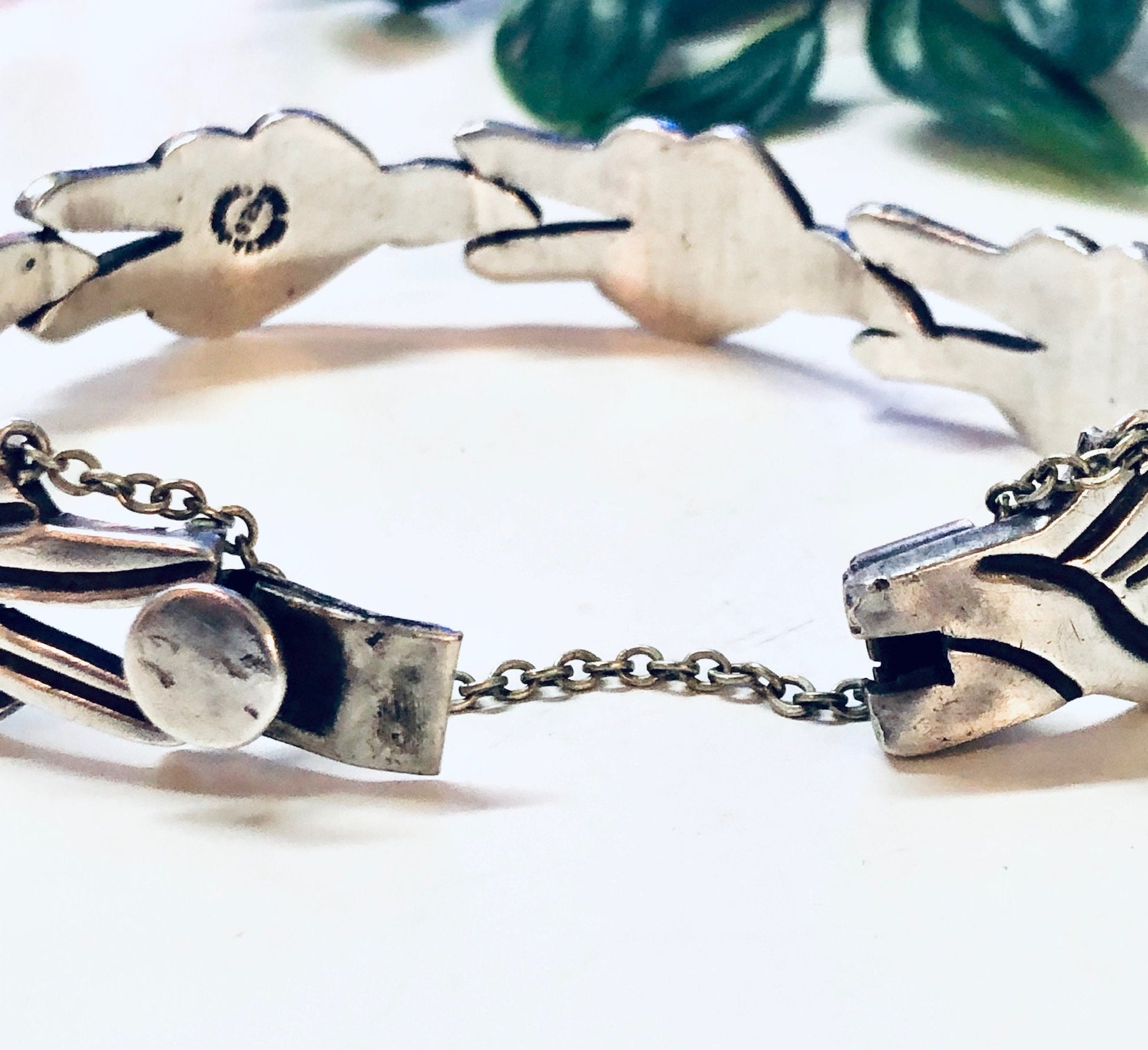 Vintage Taxco sterling silver modernist link bracelet crafted by J. Flores, showcasing an abstract geometric design. The bracelet features sculpted silver links connected by round connectors, creating an eye-catching statement piece from this renowned Mexican silver jewelry workshop.