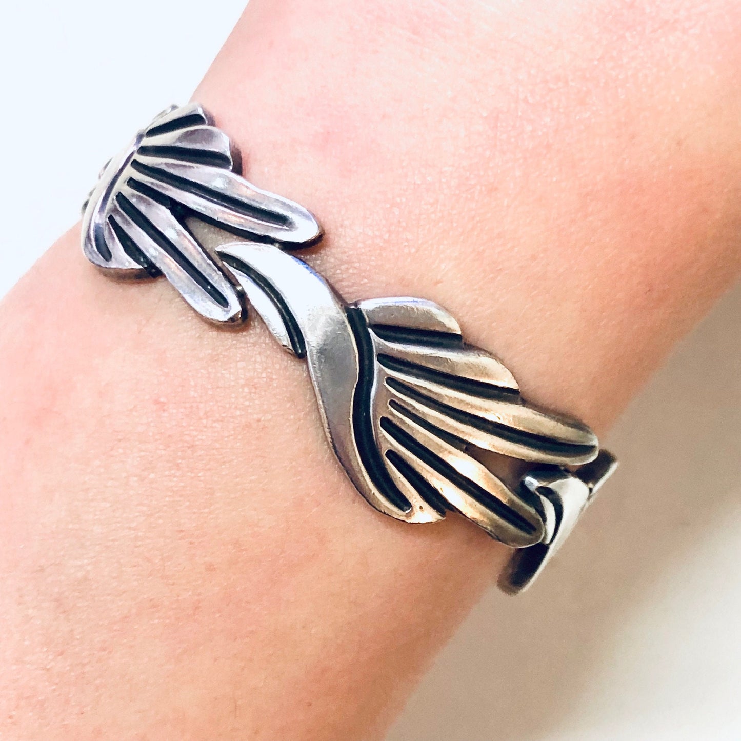 Vintage Taxco silver link bracelet with modernist swirl design, created by Mexican silversmith J. Flores, stamped 925 for sterling silver purity.