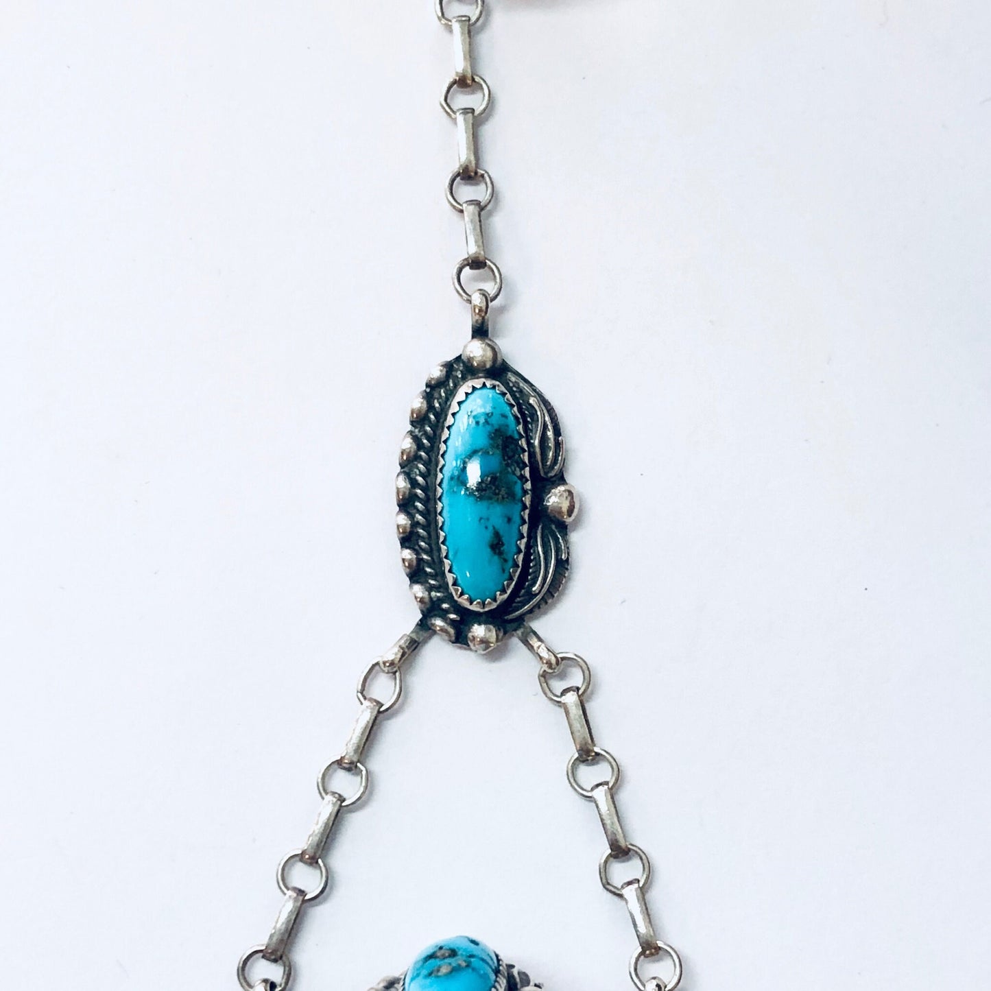 Vintage Navajo turquoise slave bracelet featuring blue turquoise stones set in an ornate silver setting, connected by silver chains. Boho style handmade Native American jewelry.