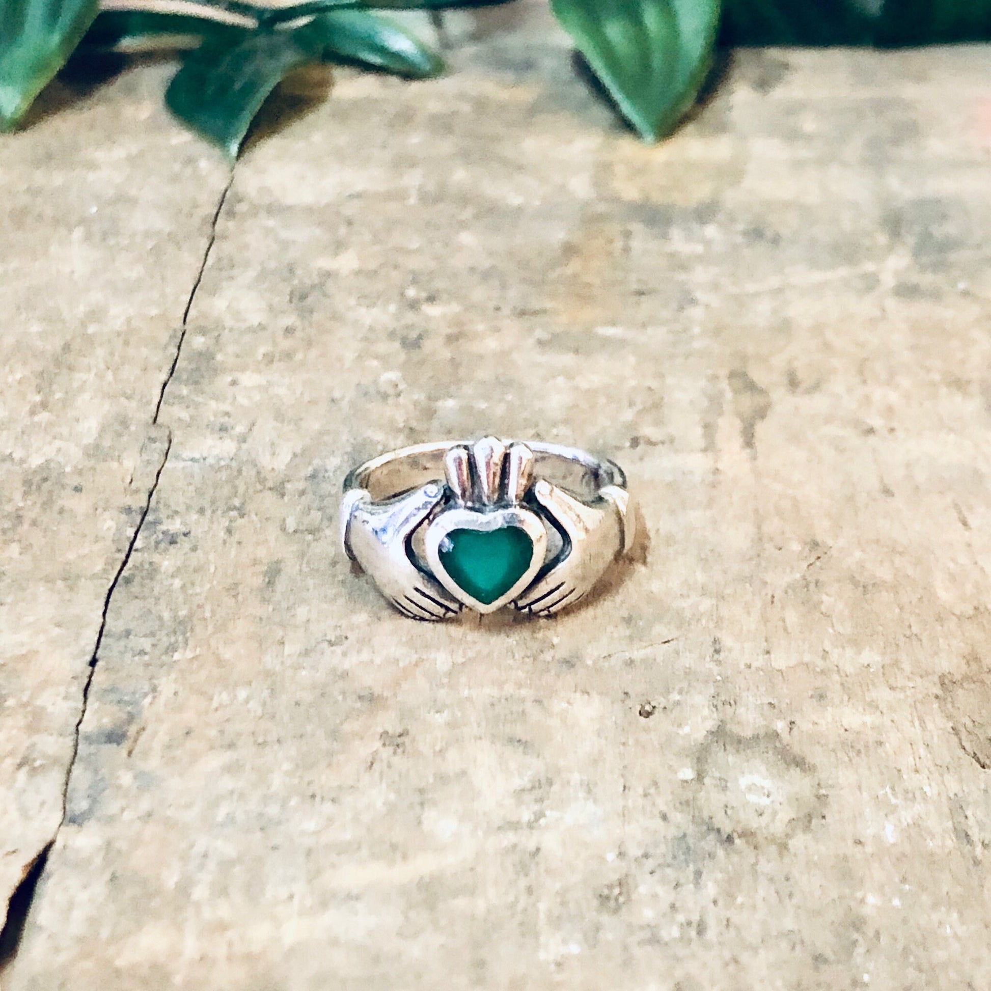 Vintage silver Claddagh ring with green enamel heart, symbolizing love and loyalty