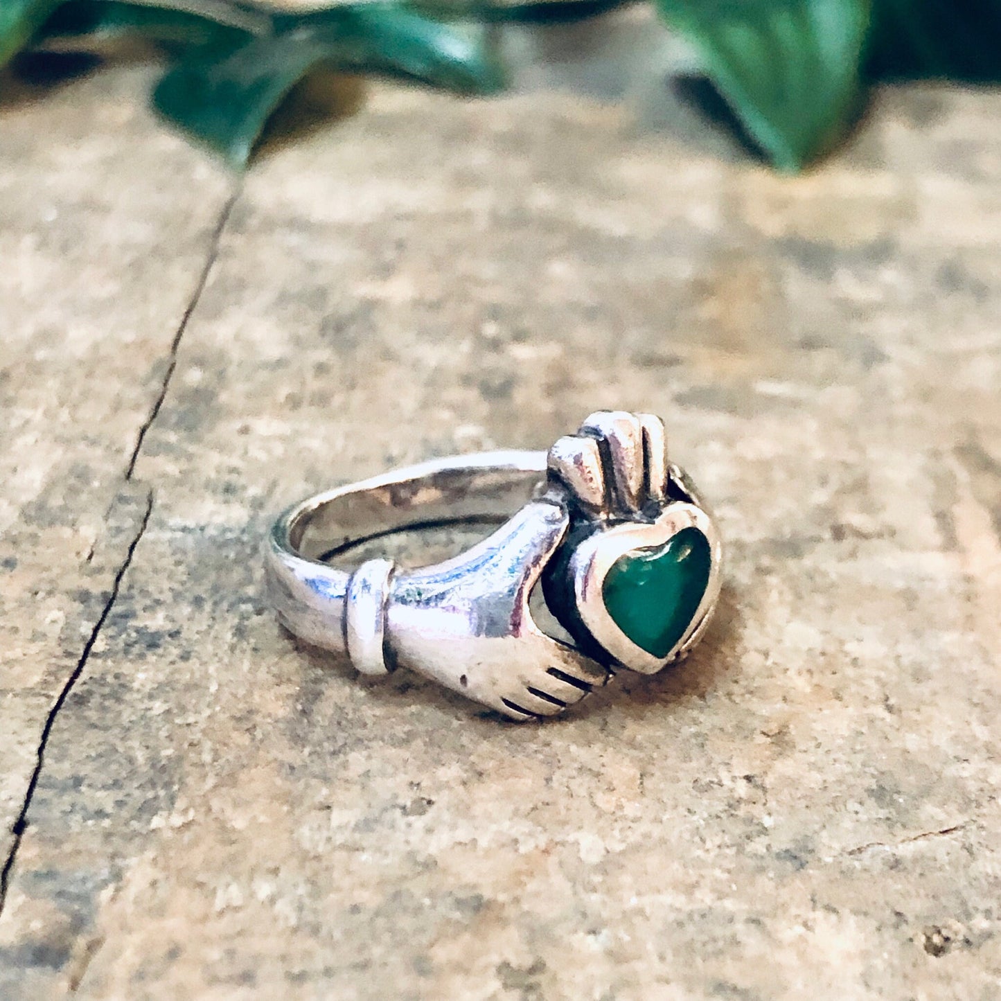 Vintage silver Claddagh ring with green enamel heart, representing love and loyalty