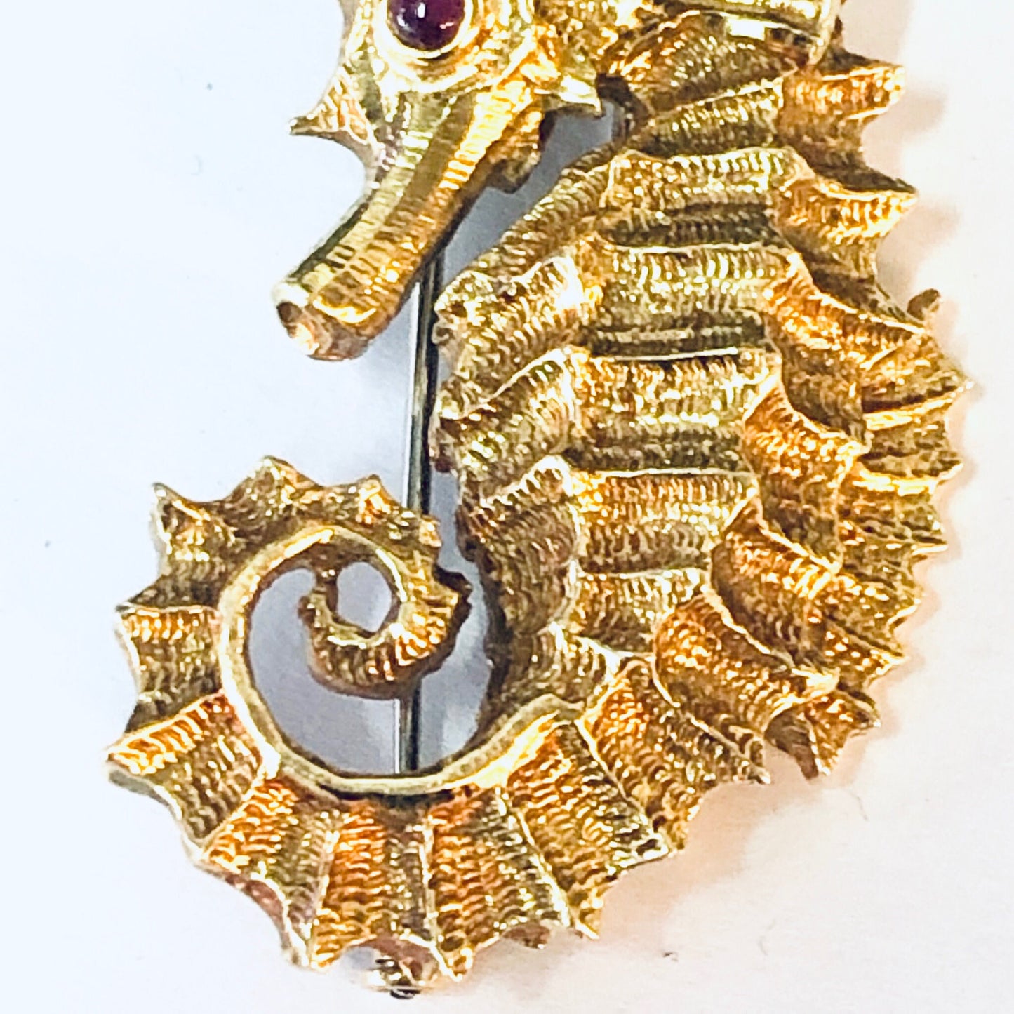 18K gold and platinum vintage David Webb seahorse brooch with ruby eye, crafted in the 1970s. The intricately textured gold seahorse design showcases Webb's signature style in this collectible statement jewelry piece.