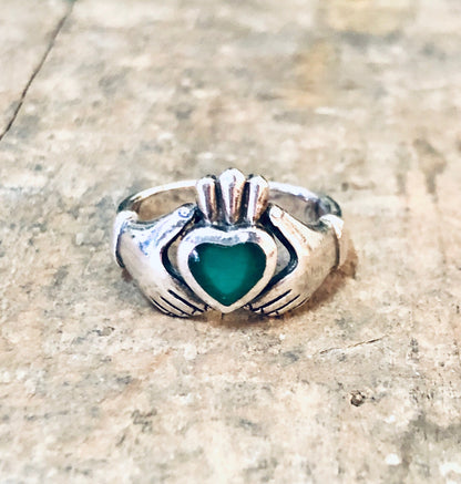 Vintage silver Claddagh ring with green enamel heart, symbolizing love and loyalty