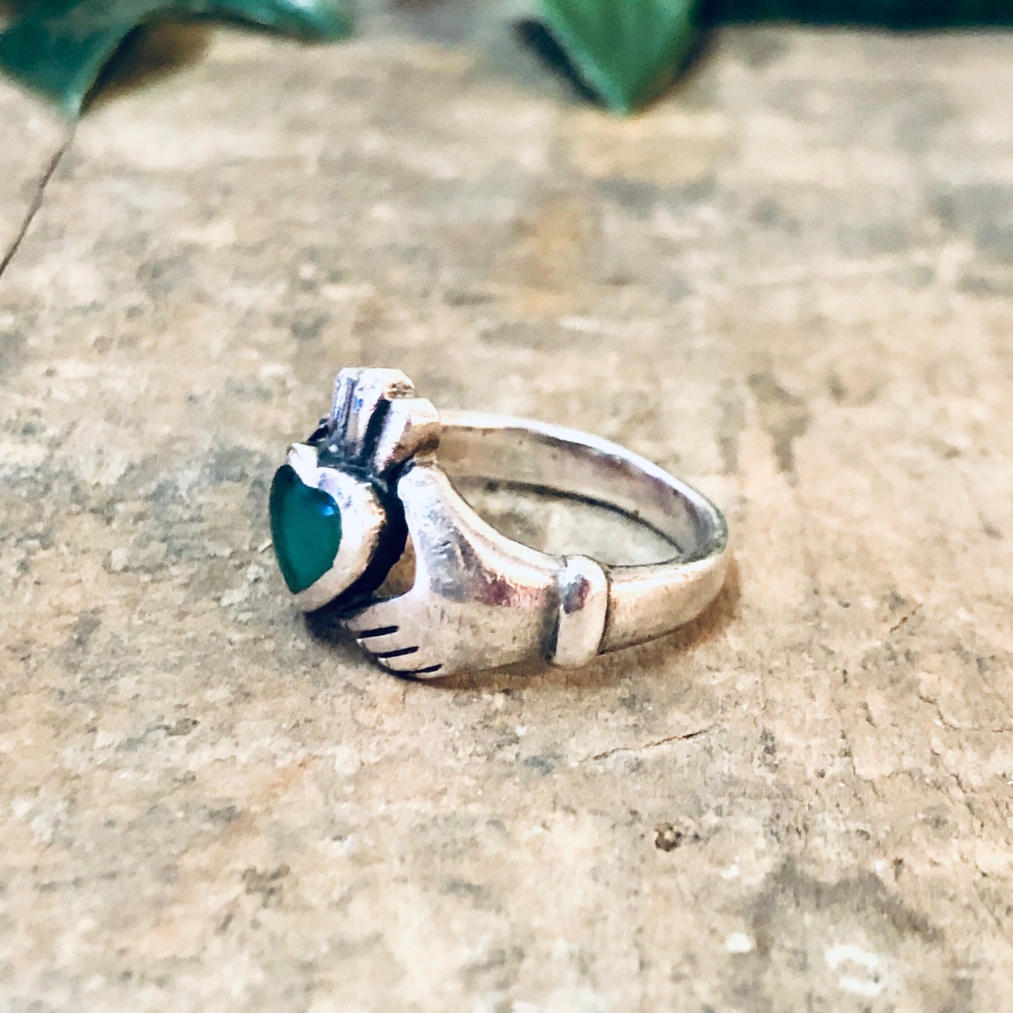 Vintage silver Claddagh ring with green enamel heart, symbolizing love and loyalty