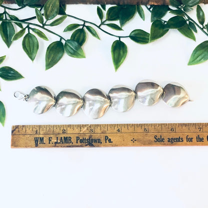 Vintage silver link bracelet with unique shell design, small size, 925 sterling silver. Ruler shown for scale with foliage in background.