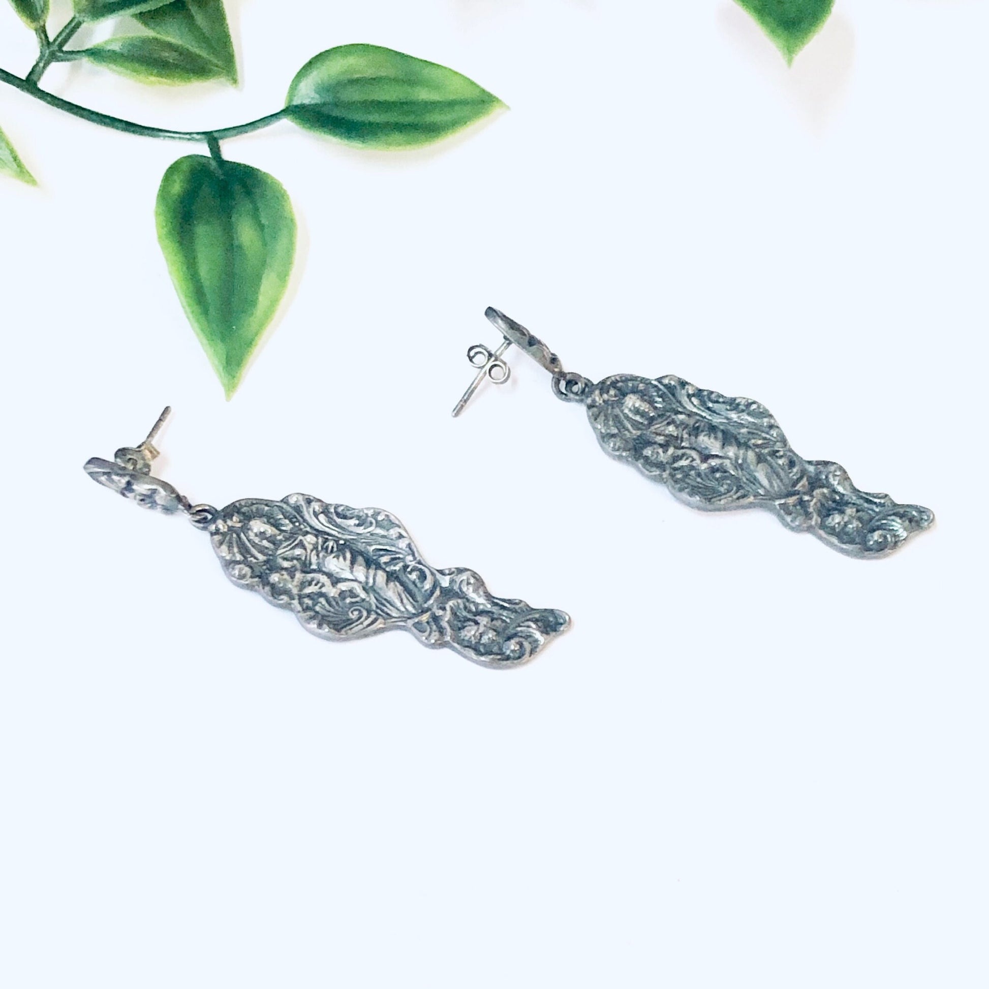 Vintage silver art nouveau style lady figurine dangle earrings with green leaf accents on white background