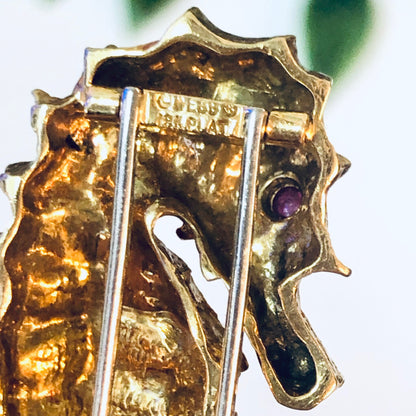 18K gold and platinum David Webb vintage seahorse brooch pin with ruby eye from the 1970s, closeup detail view.