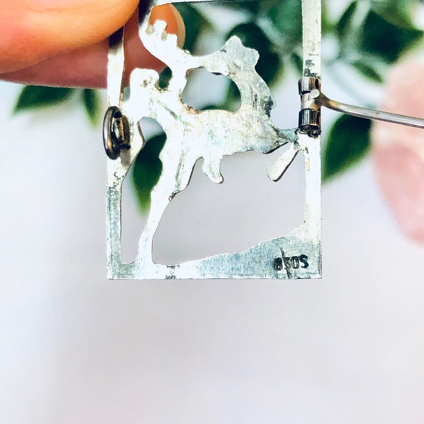 Vintage silver deer brooch featuring cut-out silhouette of man riding deer, unique animal-shaped pin jewelry.