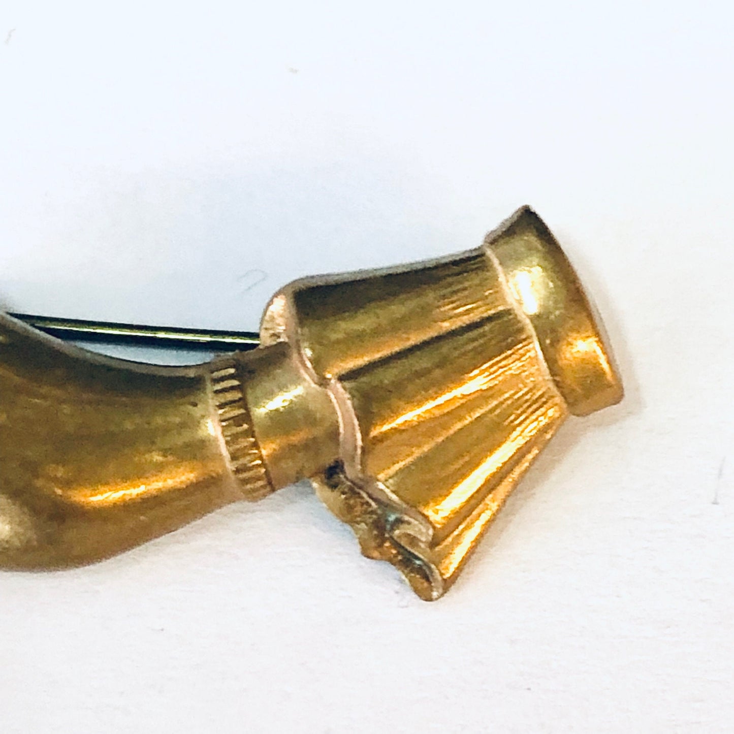 Vintage gold-toned brooch depicting two hands clasped in prayer position holding a cross, against a plain white background.