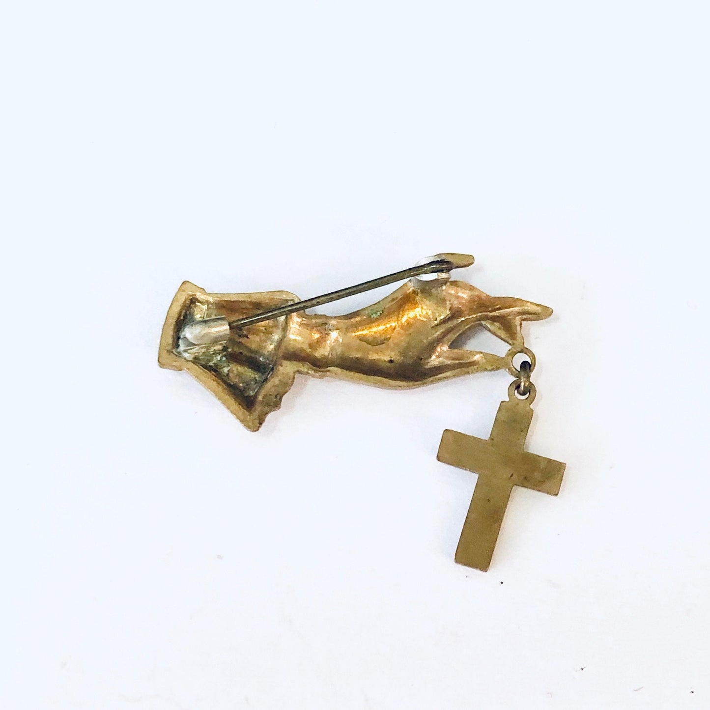 Vintage gold-toned religious brooch featuring a hand holding a cross pin, costume jewelry accessory