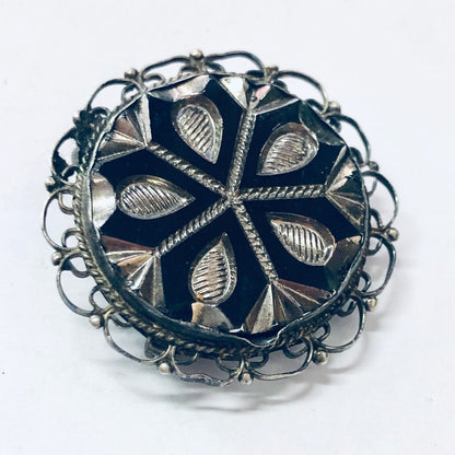 Vintage silver filigree brooch pendant with intricate floral design and dark blue enamel background, crafted in 925 sterling silver. Unique round jewelry piece can be worn as a brooch or necklace pendant.