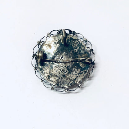 Vintage silver round brooch pendant with intricate wire design and crystals, can be worn as a necklace or unique jewelry piece.