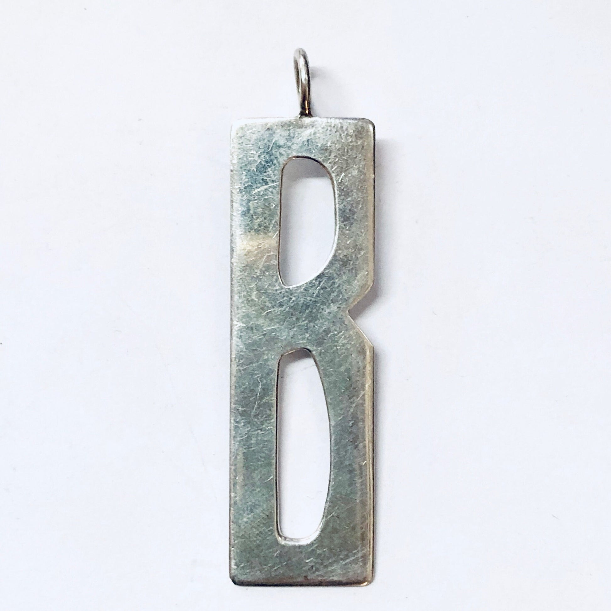 Vintage silver initial "B" pendant necklace charm, handcrafted by designer Leonore Doskow, featuring a textured rectangular shape with cut-out letter design.