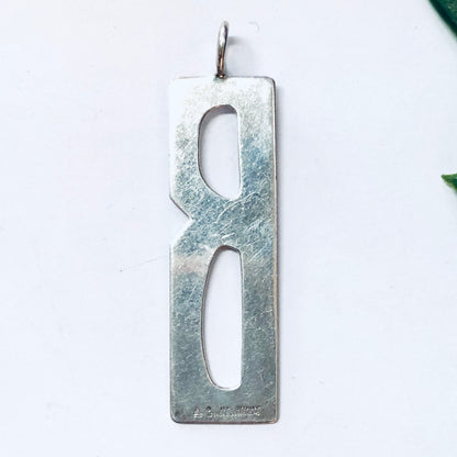 Vintage silver rectangular pendant with cutout letter "B" design, aged patina finish, made by Leonore Doskow, for necklace or charm bracelet.