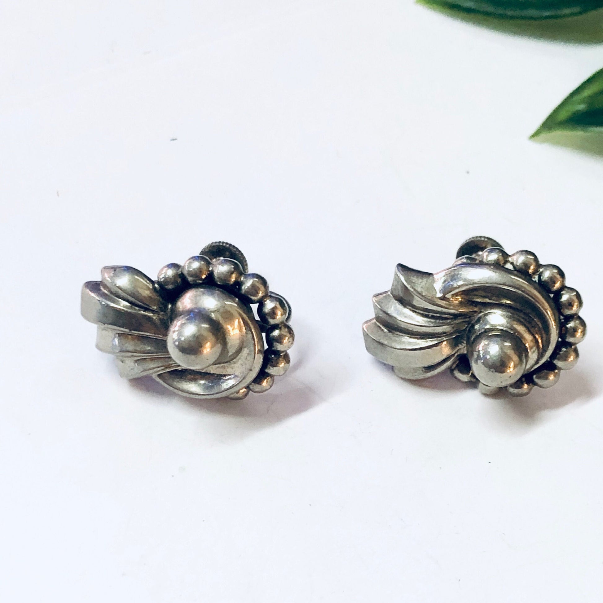 Vintage silver screw back earrings with swirled design and round accents, made by Lisner. Unique and funky vintage jewelry piece.