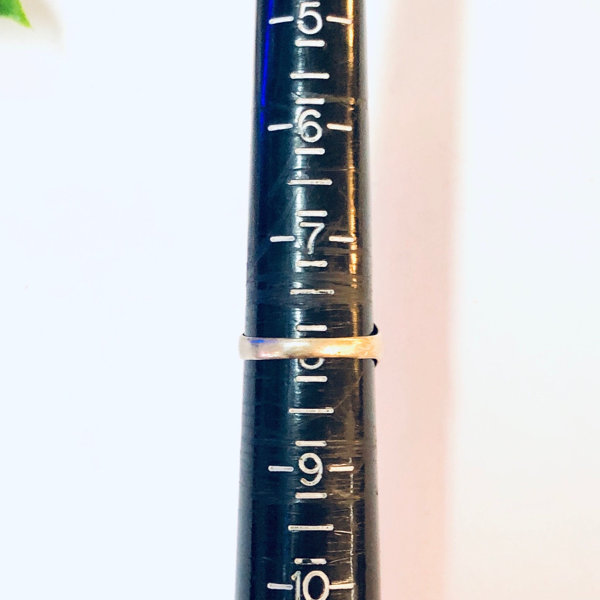 Close-up photograph of a dark blue wooden ruler marked with white numbered measurements in increments of -5. The ruler has a shallow depth of field effect, with the foreground in sharp focus while the background is blurred.