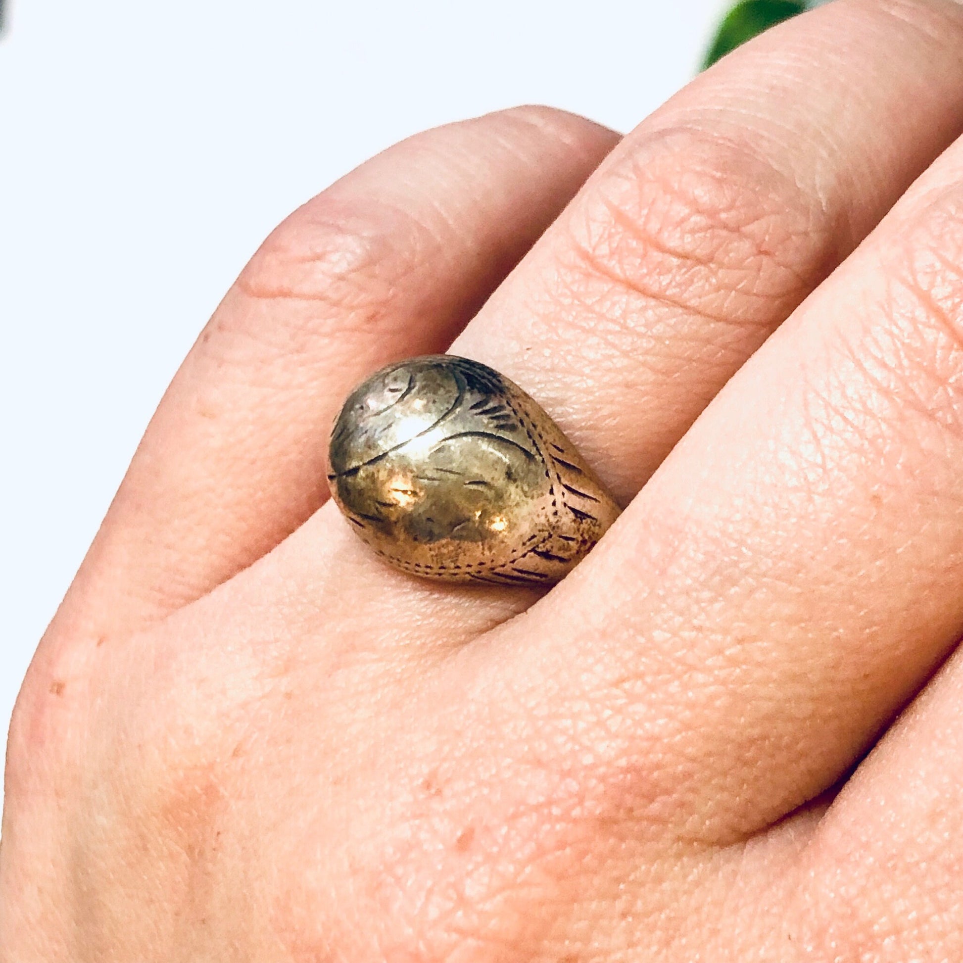 Vintage silver dome ring with intricate etched design resting on a hand, unique everyday jewelry piece.