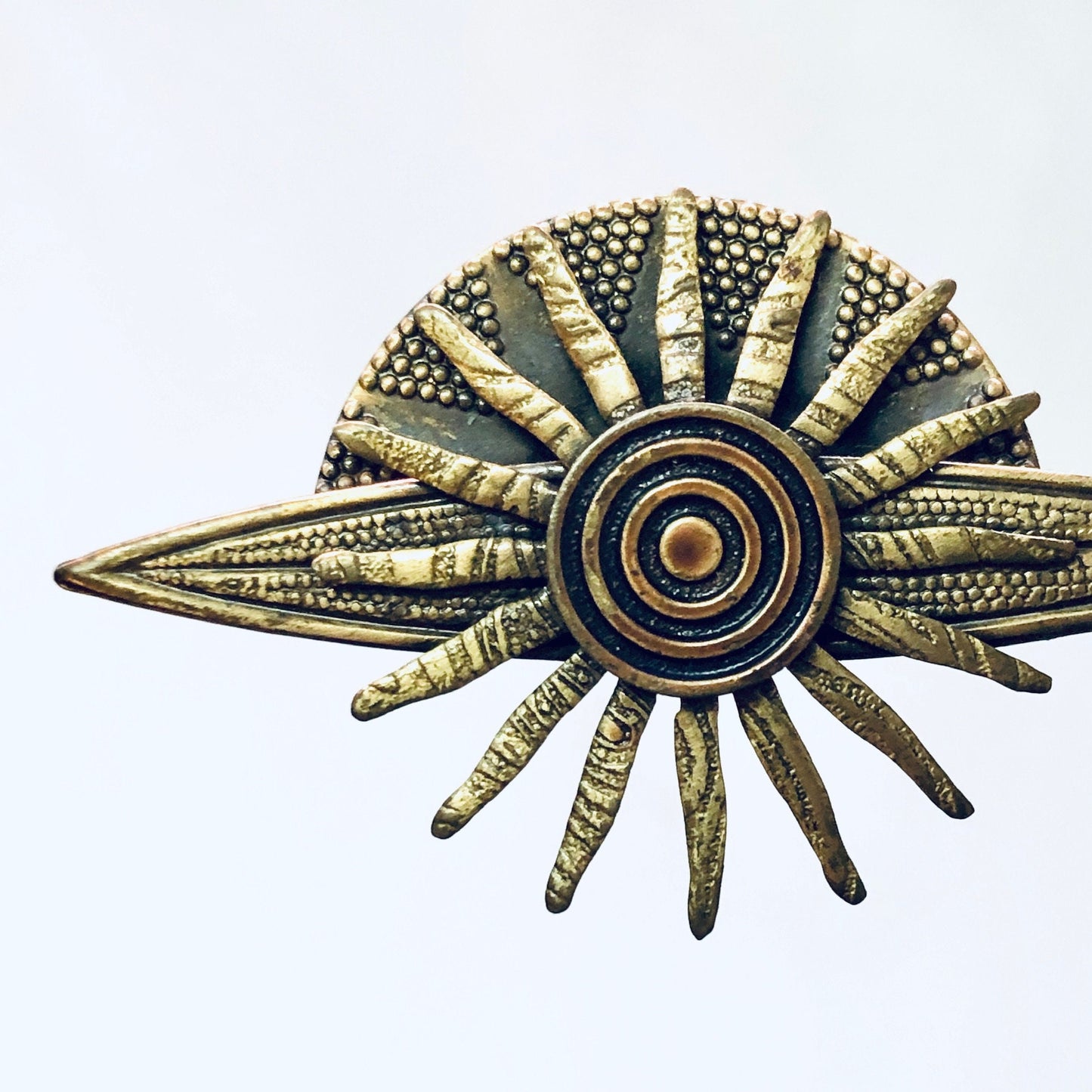 Vintage brass-toned sun brooch with intricate spiky rays resembling a solar system, perfect gift idea for lovers of celestial and planet-inspired costume jewelry from yesteryear.