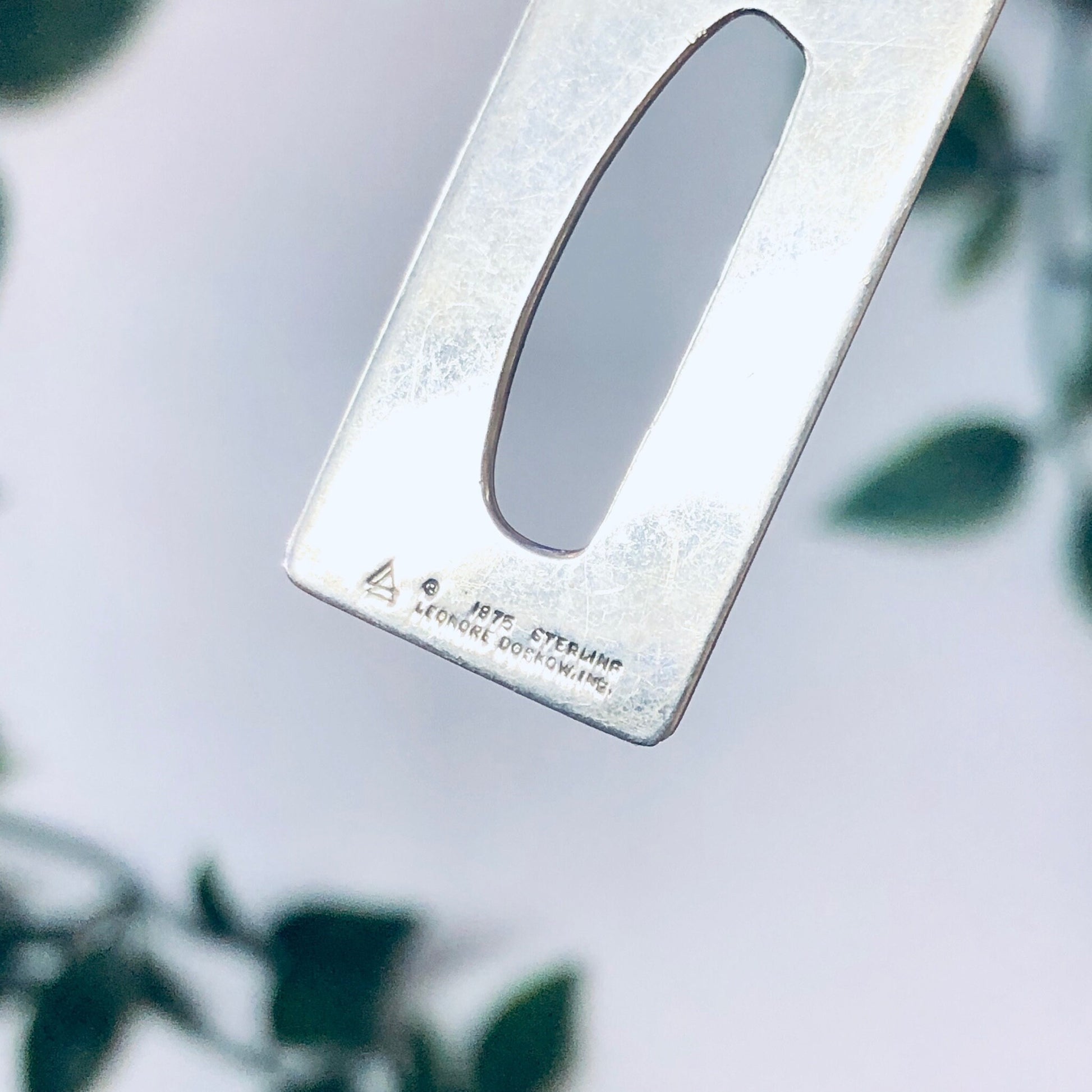 Vintage silver 925 pendant necklace with initial "B" by Leonore Doskow, photographed on a white background with leaves.