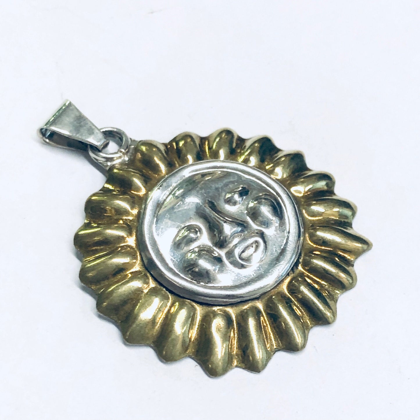 Vintage silver sun pendant featuring a detailed sun face design accented with a gold finish on the rays surrounding the face, creating a unique, eye-catching charm suitable for necklaces or other jewelry pieces.