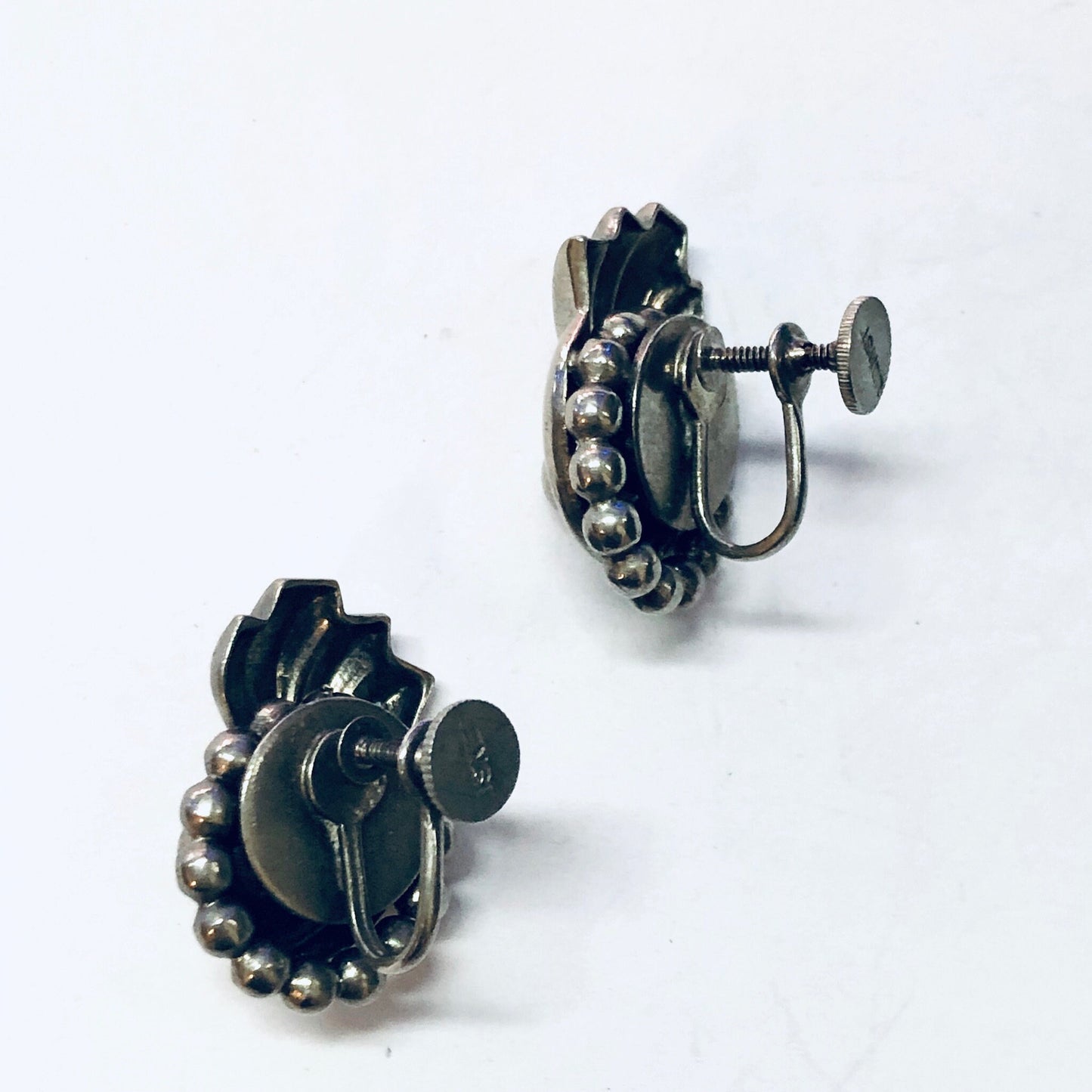 Vintage Lisner silver screw back earrings with unique, funky design featuring multiple round and oval elements.