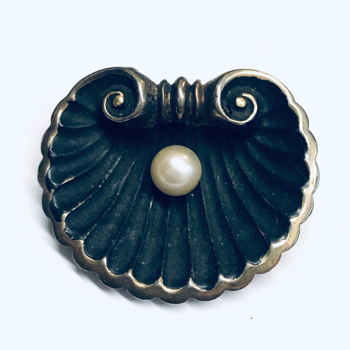 Antique black enamel and pearl brooch in a scalloped shell design with gold accents, crafted in an Art Nouveau style.