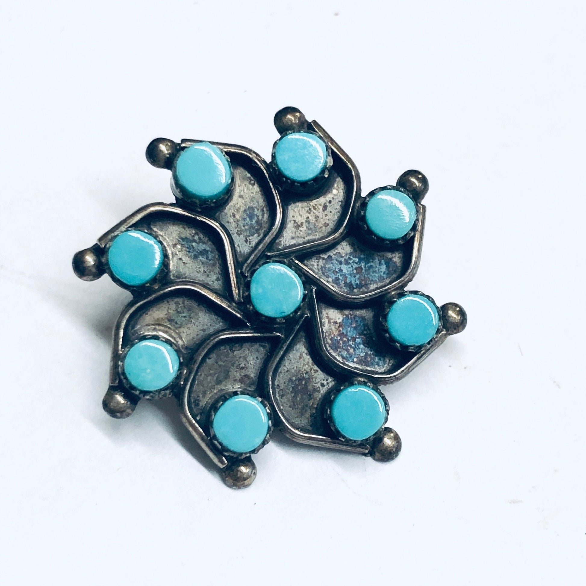 Turquoise and silver star-shaped clip-on earrings, vintage jewelry design with round turquoise cabochons set in oxidized silver curving petals, creating an eye-catching retro accessory.