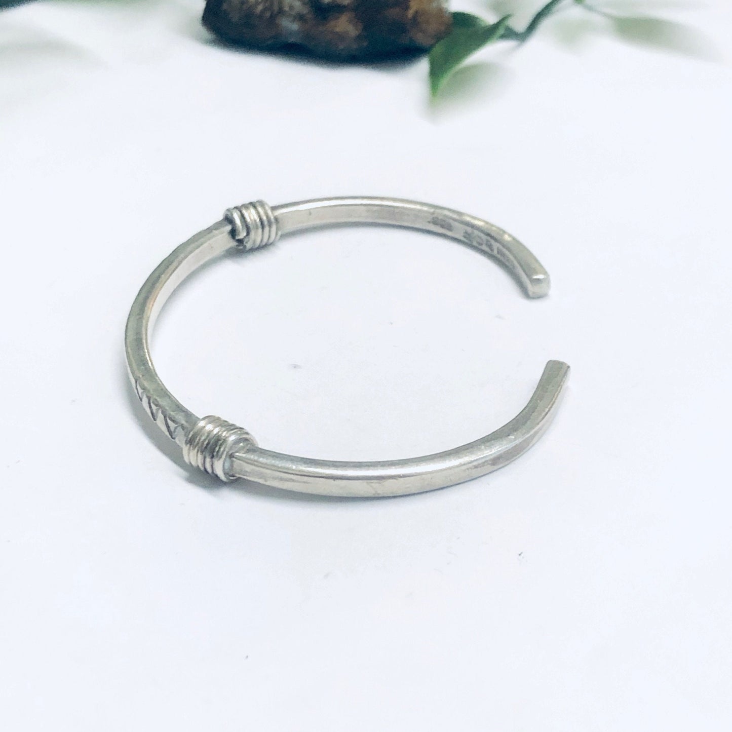 Vintage silver thin cuff bracelet with simple design on white background