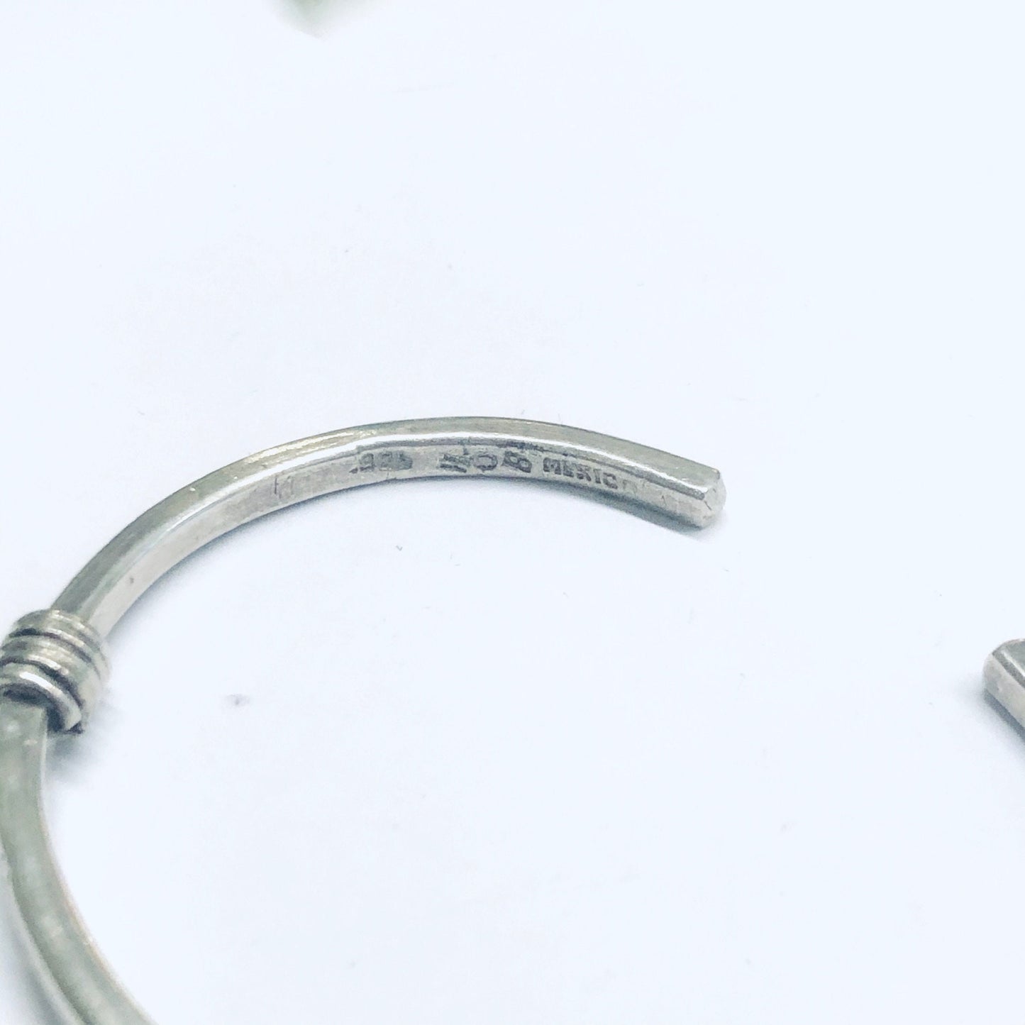 Vintage thin silver cuff bracelet with simple design and elegant curves, displayed on a white background.