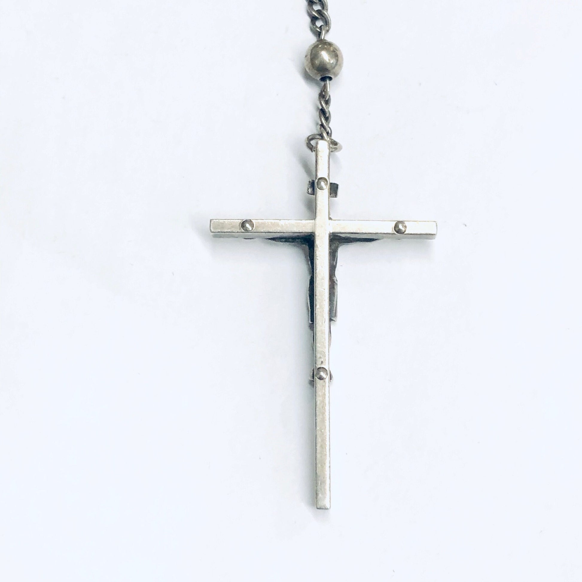 Silver crucifix pendant on rosary chain with small round prayer beads