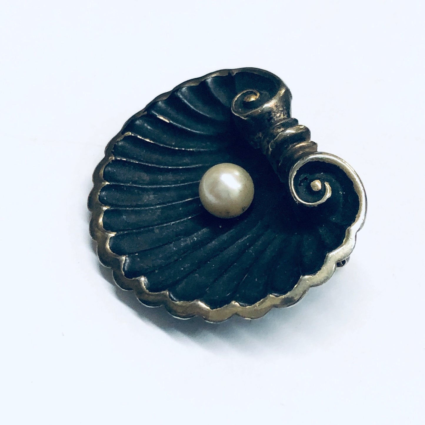 Vintage shell-shaped brooch with pearl accent and gold wash details, crafted in a matte black finish, reminiscent of Art Nouveau style jewelry pins.