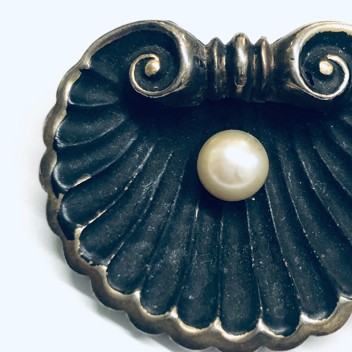 Antique sterling silver art nouveau shell brooch with pearl accent, crafted by Karen Lynne. The matte black pin features gold wash detailing and an elegant scalloped design reminiscent of a seashell.