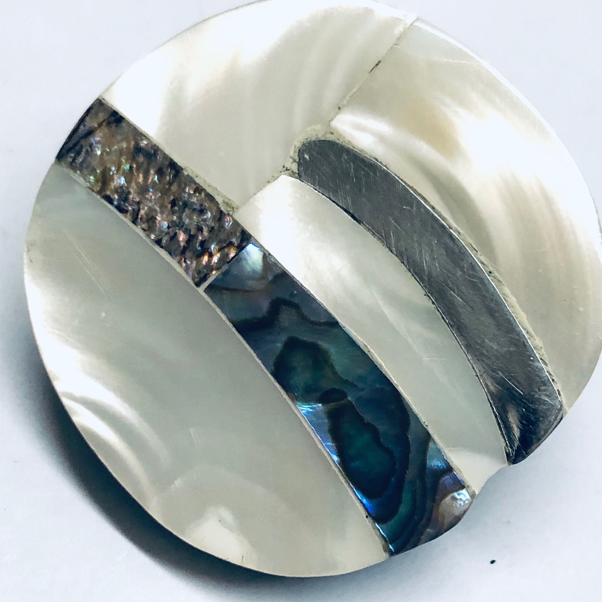 Vintage abalone shell clip-on earrings with abstract blue and white mother of pearl inlay design, shown on white background.