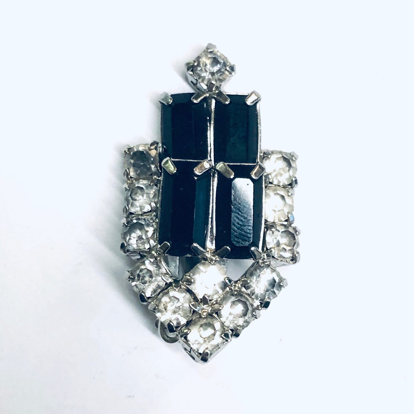 Vintage black and clear rhinestone clip-on earrings in silver tone metal setting, featuring a rectangular black center stone surrounded by sparkling clear rhinestones in an elegant retro design.