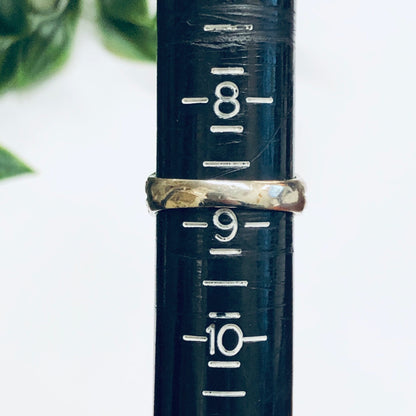 Vintage blue lapis stone ring with gold band engraved with measurement markings against a blurred green background, making a unique statement cocktail ring suitable for a Valentine's Day gift.