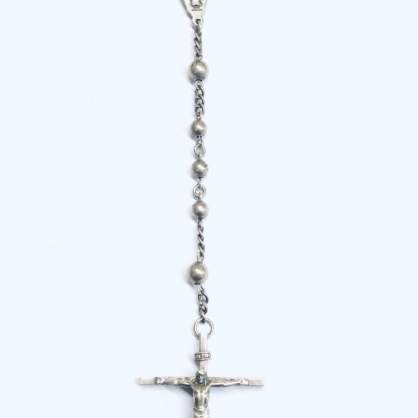 Silver rosary prayer beads with crucifix and Virgin Mary medal, religious worry beads jewelry on white background