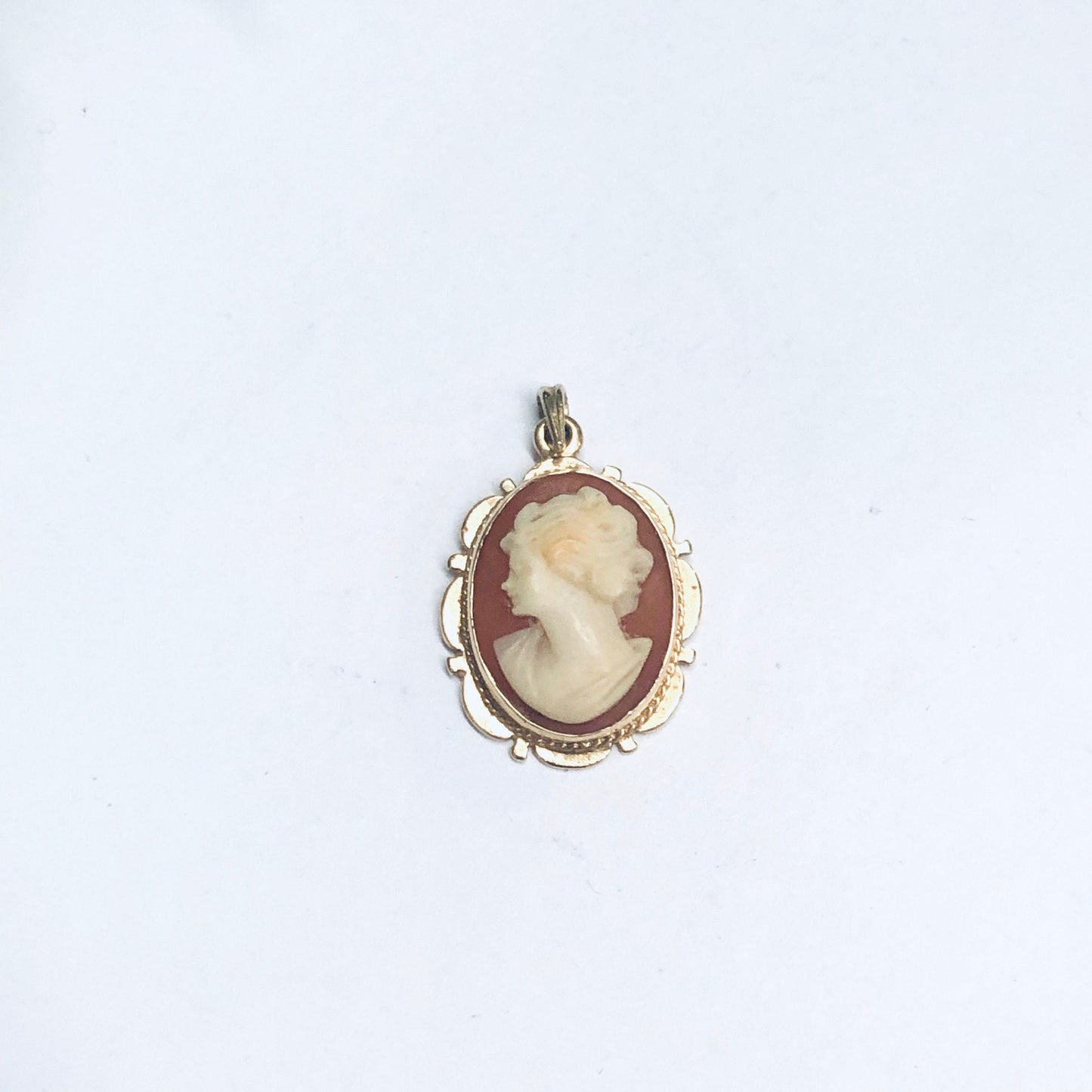 Vintage 14K yellow gold oval cameo pendant featuring a carved profile portrait set in an ornate border on a plain white background.