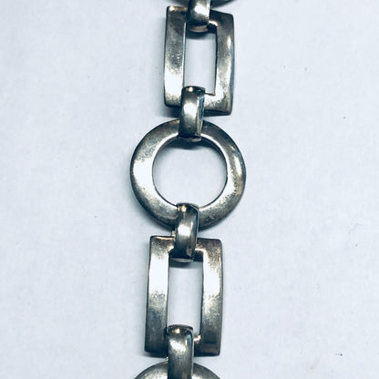 Vintage silver geometric link bracelet with circular and rectangular cut-outs and toggle closure