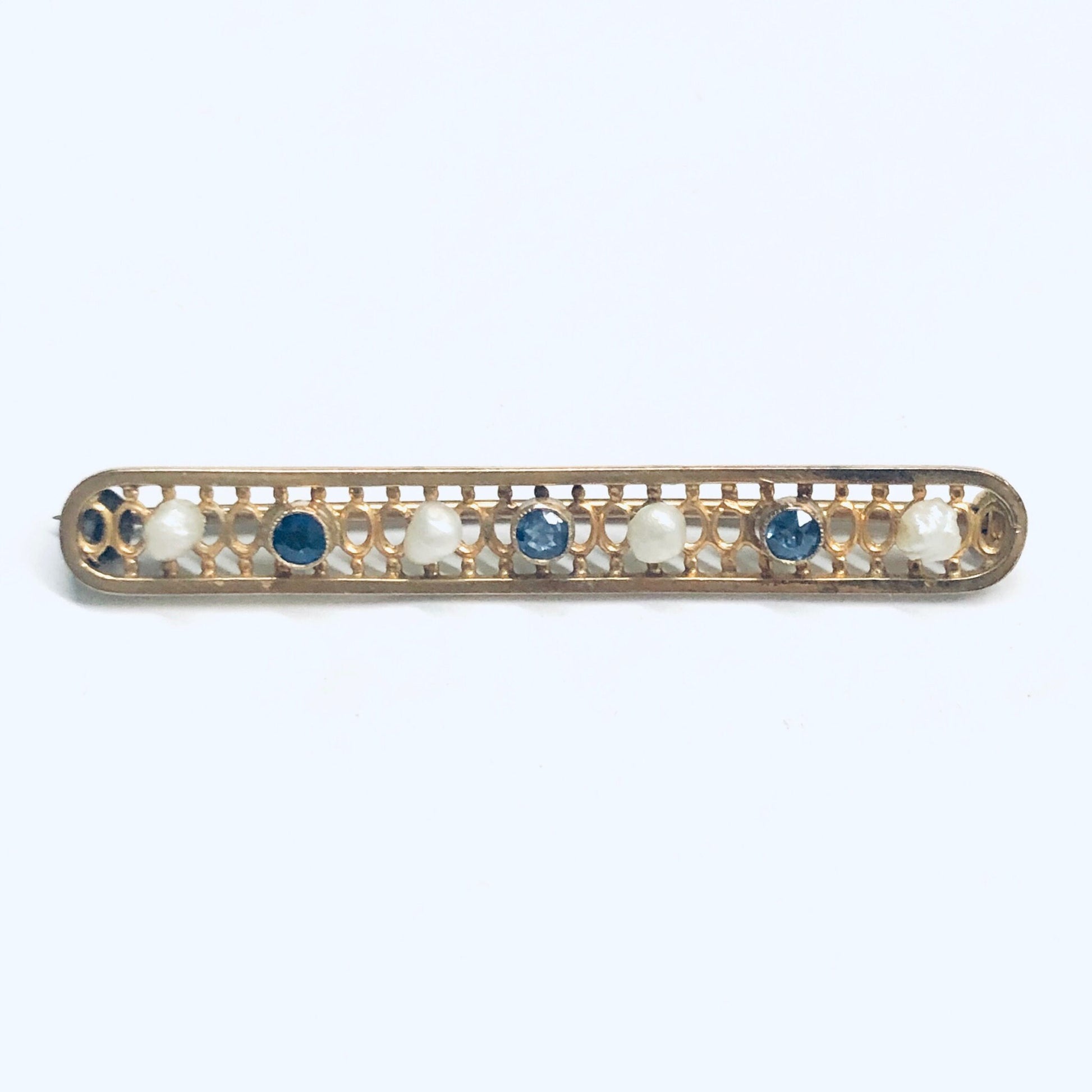 Vintage 14K yellow gold bar pin featuring a lattice design accented with seed pearls and faceted blue gemstones. Measures 1 3/4 inches long. Cute jacket or lapel pin.