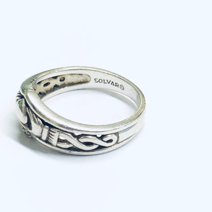 Silver Solvar Claddagh ring with intricate Celtic knot design on the band, featuring two hands holding a crowned heart, a traditional Irish symbol representing love, loyalty and friendship.