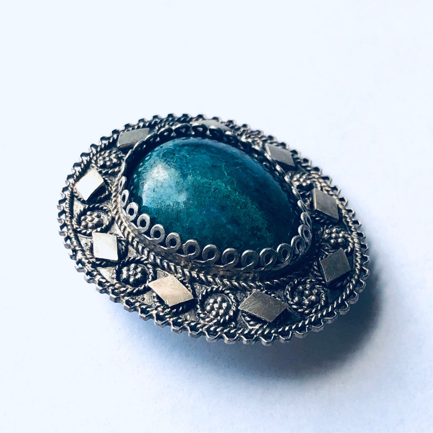 Vintage silver brooch pendant with green stone and intricate floral design, a unique Mother's Day gift idea