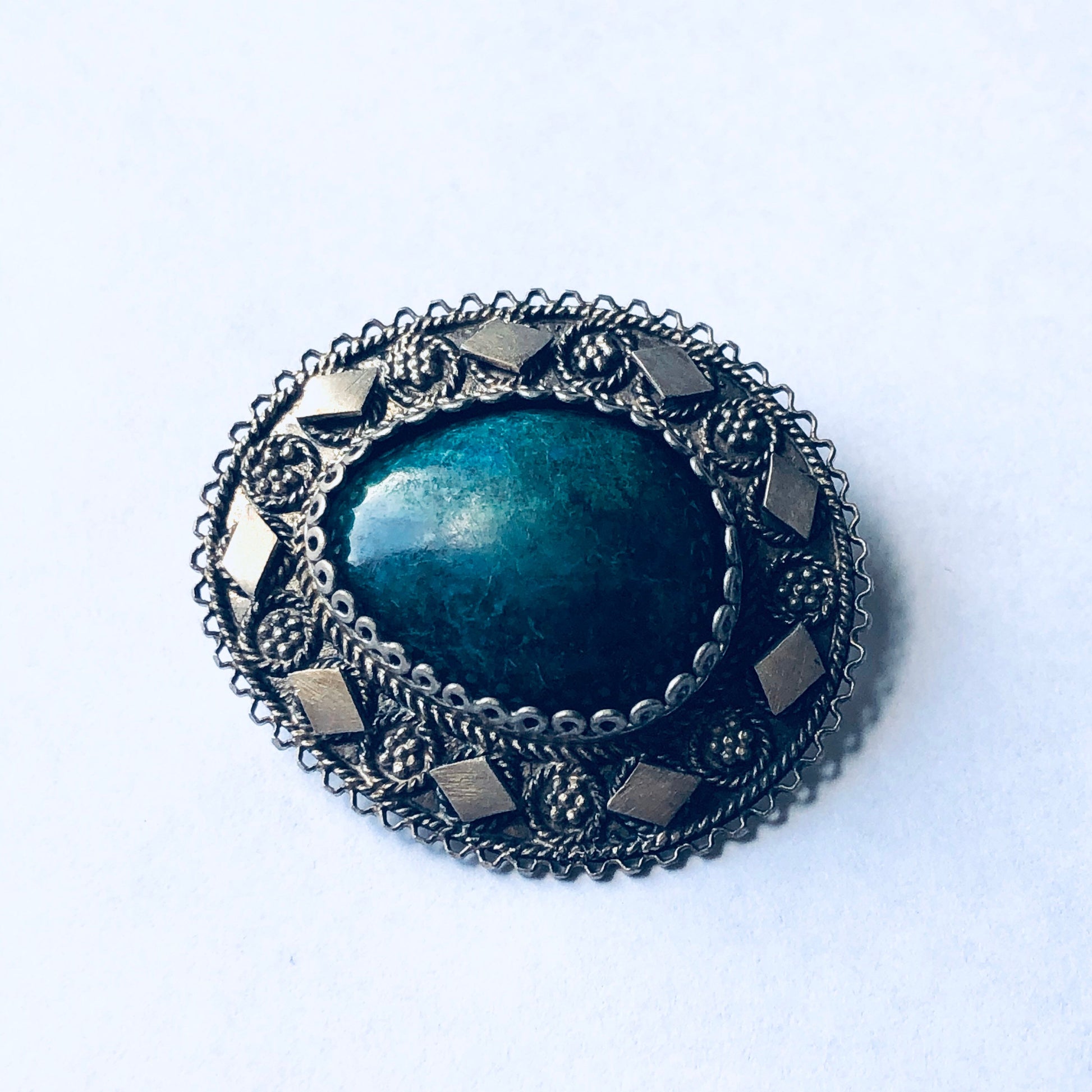 Vintage silver brooch with dark green stone pendant in an intricate floral design, suitable as a unique jewelry gift for Mother's Day or other special occasions.