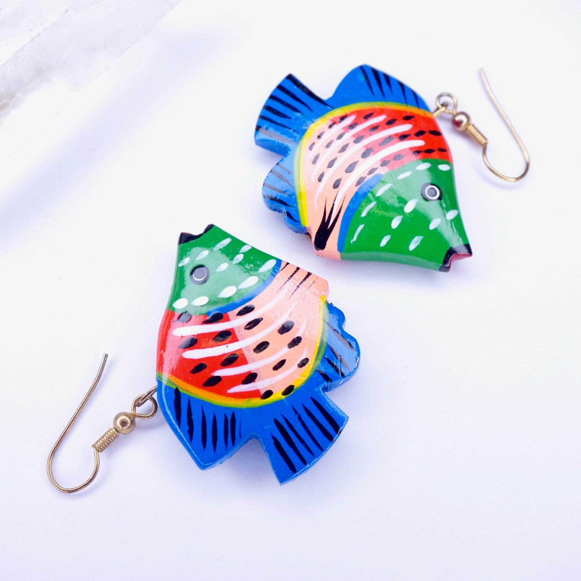 Vintage wood carved fish earrings, colorful painted wood dangle earrings with intricate detail, handmade wooden statement jewelry on a white background.