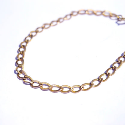 Vintage 10K gold Cuban chain bracelet with delicate, minimalist style, measuring 7 inches long.