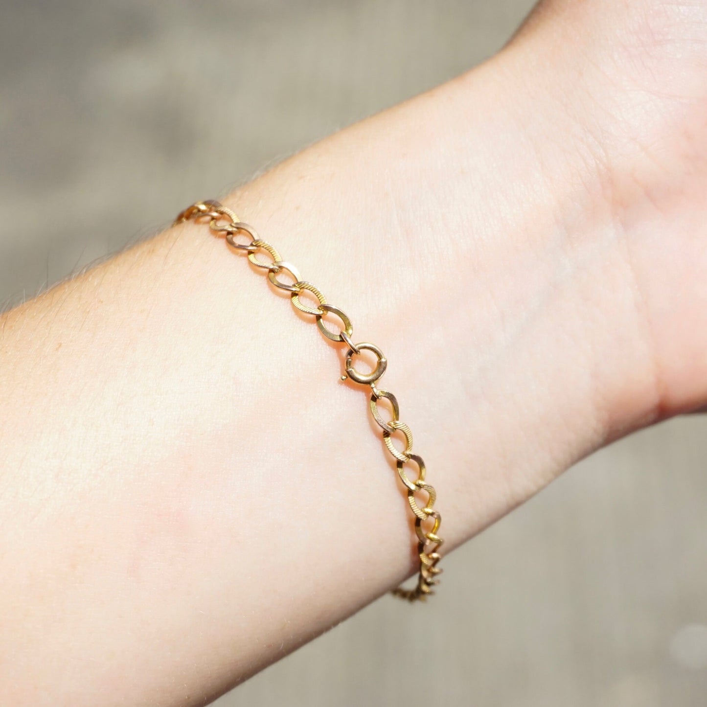 Delicate vintage 10K gold Cuban chain bracelet on wrist, measuring 7 inches long. Minimalist gold chain bracelet for a simple, elegant look.