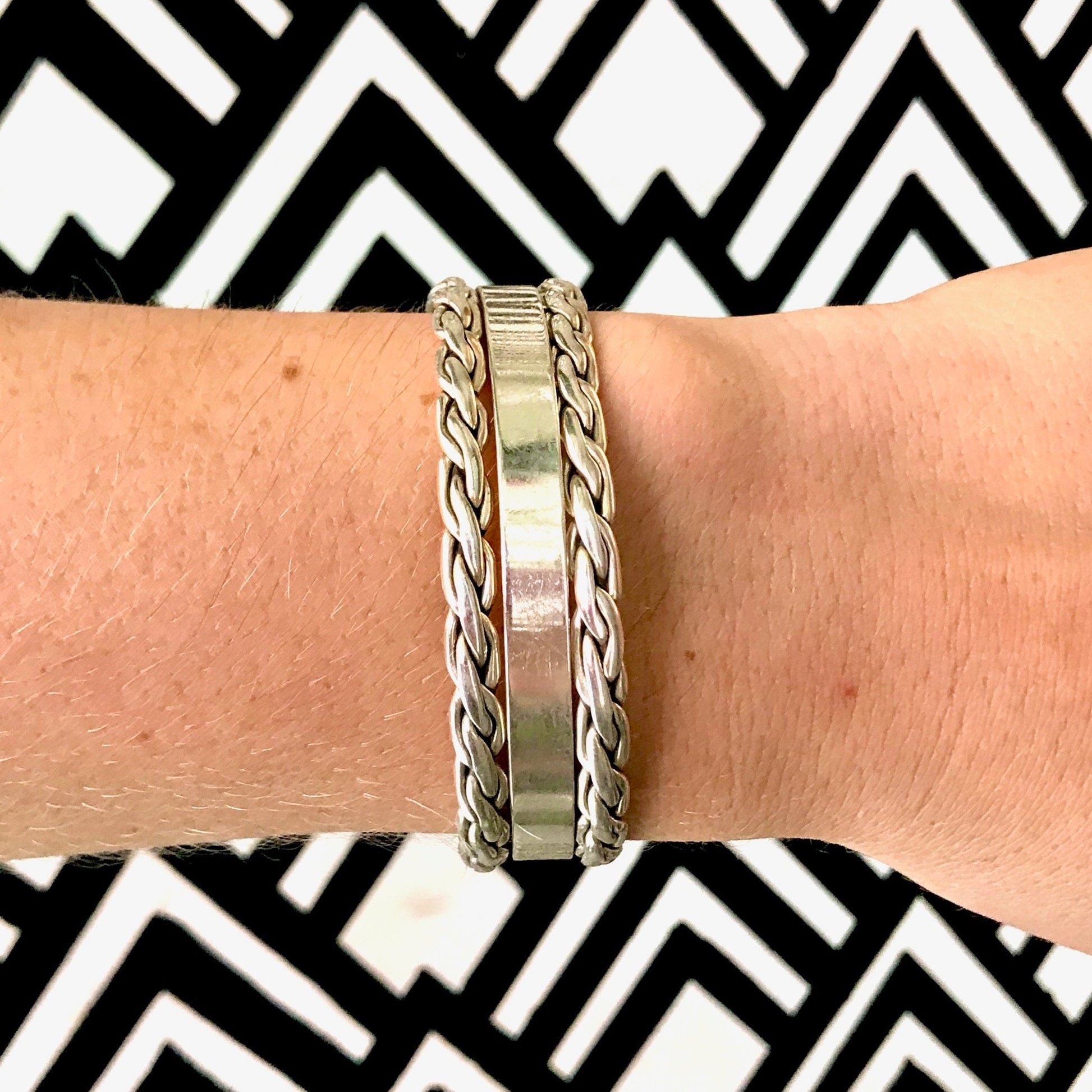 Vintage sterling silver weave cuff bracelet with minimalist design, made in Mexico, stamped "Mex 925 TE-51", shown on wrist against geometric black and white patterned background.